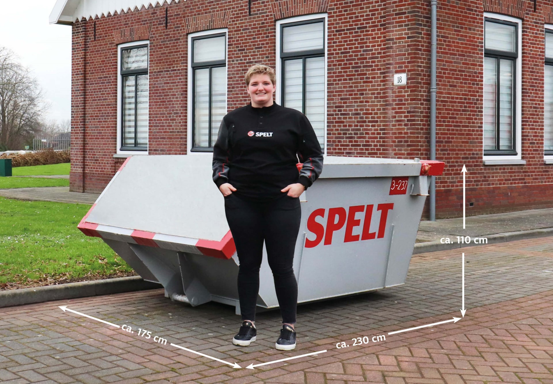 vrouw voor container van Spelt op straat